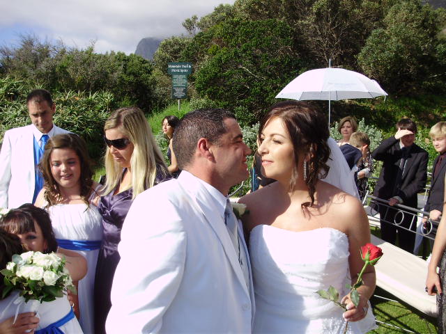 Sandro whispering a promise in Tammy's ear. Ceremony held in the Fynbos Garden at the 12 Apostles Hotel  